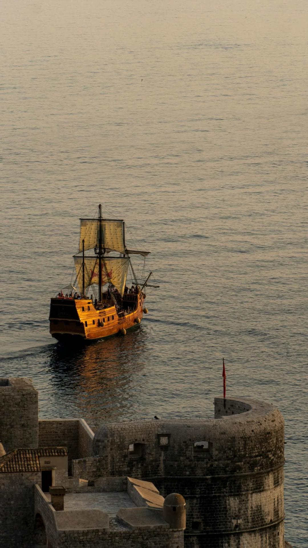 Wooden galleon leaving Dubrovnik Old Port at golden hour