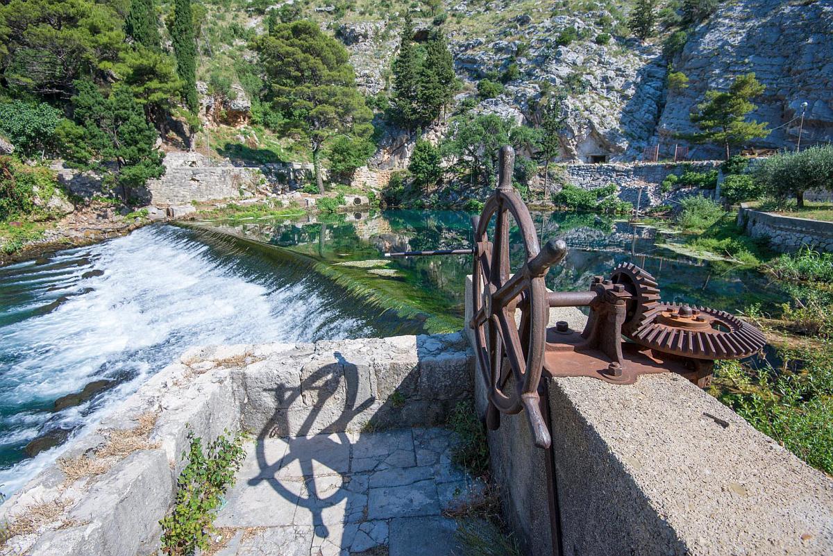 Historic iron water wheel overlooking the emerald River Ombla