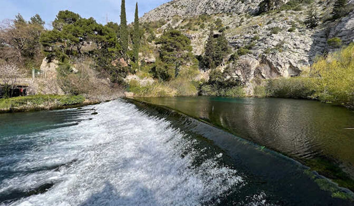 Cascading waterfall on the River Ombla surrounded by lush greenery
